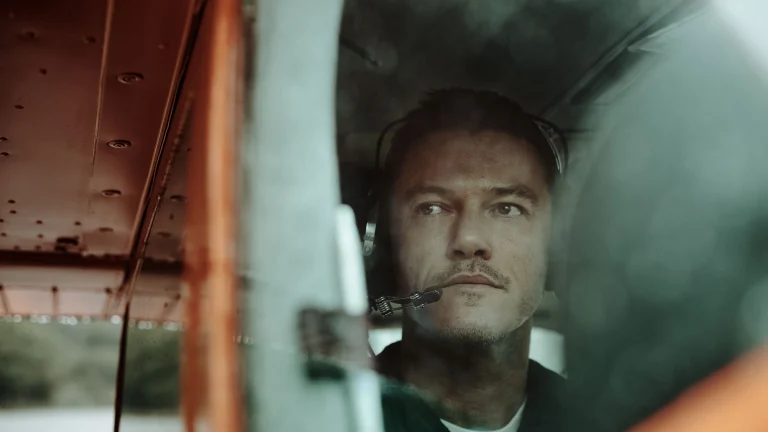 Luke Evans in small plane with headset, ready for takeoff
